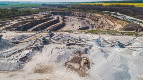 Aerial view of the granite quarry. Development of granite rock in Ukraine. Processing plant for crushed stone and gravel. Mining and Quarry mining equipment.